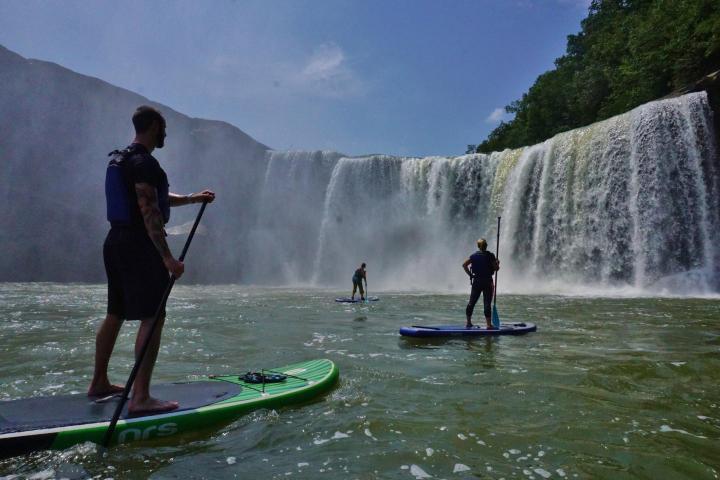 a man and a woman riding a wave on a surfboard in the water