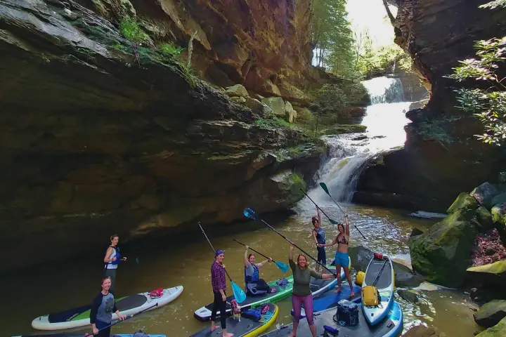 a group of people standing next to a river