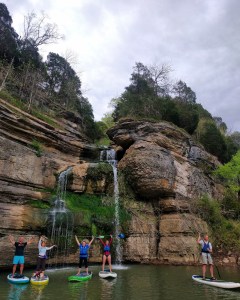 a group of people standing next to a body of water