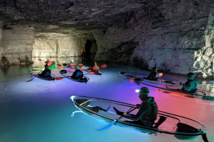 a group of people riding on the back of a boat in the water